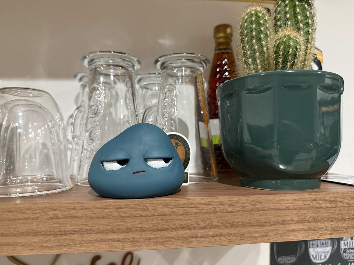 A small blue unimpressed character on a kitchen shelf